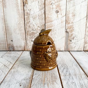 Tarro de miel de cerámica vintage con forma de colmena y tapa; tarro de miel esmaltado con forma de panal y abejas en relieve.