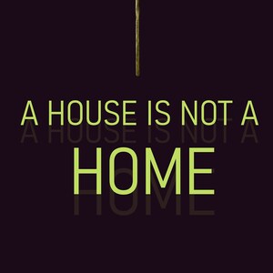 May include: A lit matchstick with a green flame against a dark background. The text "A house is not a home" is written in green below the matchstick.