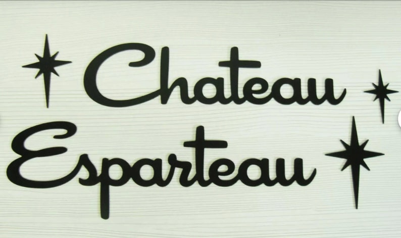 May include: Black wooden sign with the text "Chateau Esparteau" in a retro font. The sign is decorated with stylized starbursts.