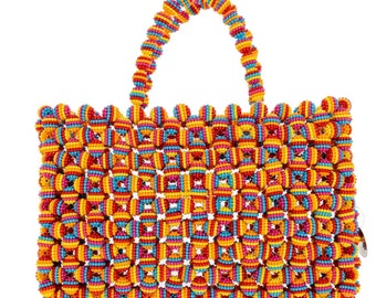 May include: A colorful beaded tote bag with a woven design. The bag is made of small, round beads in shades of yellow, orange, pink, blue, and turquoise.