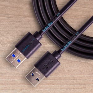 May include: Two black USB-A to USB-C cables with the text "SatelliteSale" printed on them. The cables are coiled up and the ends are visible.