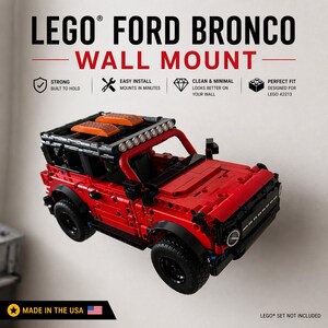 May include: A red LEGO Ford Bronco model mounted on a wall. The image includes text that reads "LEGO Ford Bronco Wall Mount" and "Made in the USA". The model is designed for LEGO 42213.