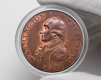 May include: A copper coin featuring a profile of George Washington with the inscription "WASHINGTON PRESIDENT 1791".