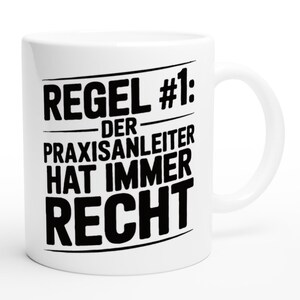 Könnte beinhalten: Weiße Keramik-Tasse mit schwarzem Text: "REGEL #1: DER PRAXISANLEITER HAT IMMER RECHT". Die Tasse hat einen Standardgriff und ist für heiße oder kalte Getränke geeignet.
