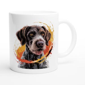 Könnte beinhalten: Weiße Keramiktasse mit einer detaillierten Illustration eines braunen und schwarzen Hundes mit weißer Schnauze und gelben Augen. Der Hund ist vor einem lebendigen orange-gelben Spritzdesign platziert. Die Tasse hat einen gebogenen Griff.