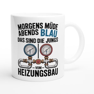 Könnte beinhalten: Weiße Keramik-Tasse mit Henkel, mit deutschem Text und einer Grafik von zwei Manometern, die durch Rohre verbunden sind. Der Text lautet "Morgens müde abends blau das sind die Jungs vom Heizungsbau."