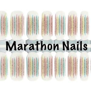 May include: Nail wraps with a white base and vertical stripes in pastel colors of pink, yellow, and blue, with a glittery accent. The text "Marathon Nails" is displayed in black.