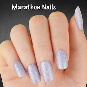 May include: A hand with five nails painted in a light purple glitter polish. The nails are a mix of square and almond shapes. The text "Marathon Nails" is at the top of the image.