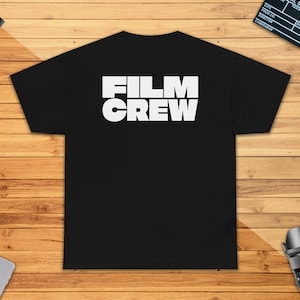 Peut inclure: T-shirt noir avec le texte blanc "FILM CREW" au dos.