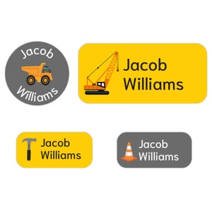 May include: Four construction-themed personalized name labels. The labels feature a yellow background with a gray border and a black outline. The labels feature a dump truck, a crane, a hammer, and a traffic cone. The labels are personalized with the name "Jacob Williams".