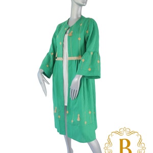 May include: A long, green, lightweight jacket with gold embroidery and tassels. The jacket has a round neckline and long sleeves with bell bottoms. The jacket is made of a soft, breathable fabric and is perfect for layering.