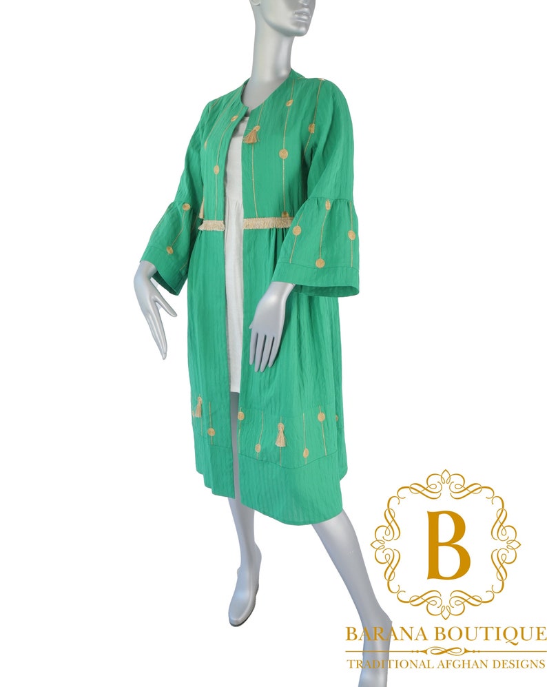May include: A long, green, lightweight jacket with gold embroidery and tassels. The jacket has a round neckline and long sleeves with bell bottoms. The jacket is made of a soft, breathable fabric and is perfect for layering.