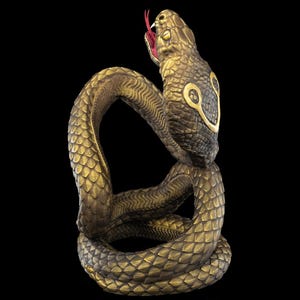 a statue of a snake on a black background