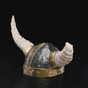a helmet with horns is shown on a black surface