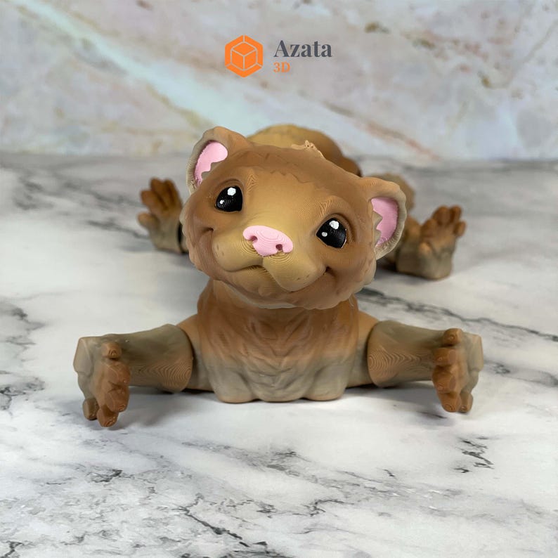 a small toy bear sitting on a marble surface