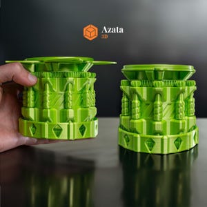 May include: Two green 3D printed objects with intricate designs. The objects are made up of multiple layers and have a textured surface. The objects are similar in shape and size, but one is slightly larger than the other.