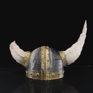 a helmet with horns is shown on a black surface