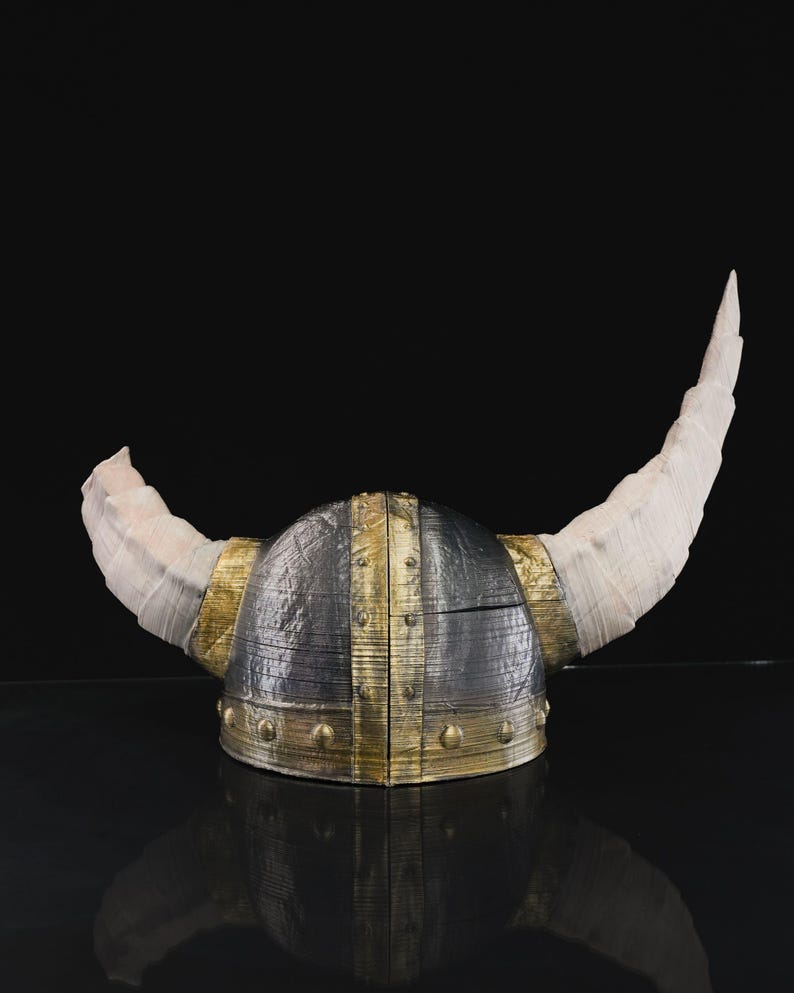 a helmet with horns is shown on a black surface