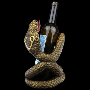 a snake holding a bottle of wine in it's mouth