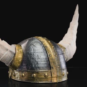 a helmet with horns is shown on a black surface