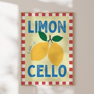 May include: A yellow and white poster with red and white checkered border. The poster says "Limon Cello" in blue text with the words "la dolce vita" in smaller text. Two yellow lemons with green leaves are pictured in the center.