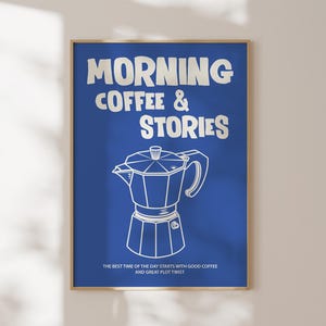 Może przedstawiać: Oprawiony wydruk artystyczny z niebieskim tłem i białym tekstem z napisem "MORNING COFFEE & STORIES". Poniżej tekstu znajduje się biały rysunek linii ekspresu do kawy. Dolny tekst brzmi "THE BEST TIME OF THE DAY STARTS WITH GOOD COFFEE AND GREAT PLOT TWIST."