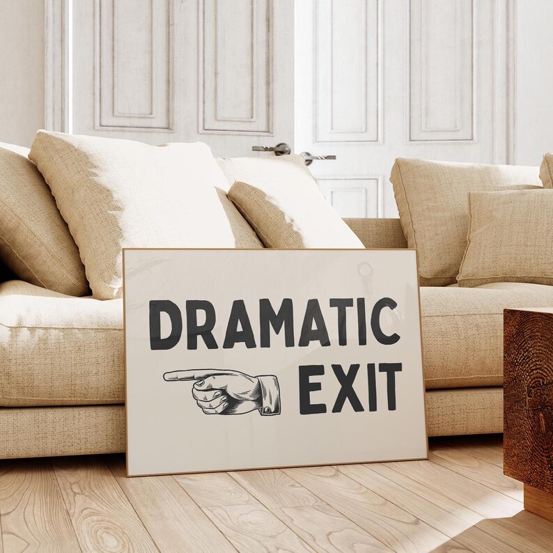 May include: A white sign with black text that reads "Dramatic Exit" with a black and white illustration of a hand pointing to the right.