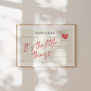Pu&ograve; includere: Stampa incorniciata con design di cartolina. Il testo "POST CARD" &egrave; in alto, con "It's the little things" in corsivo rosso. Sono visibili anche un timbro a forma di cuore rosso e linee per la scrittura.