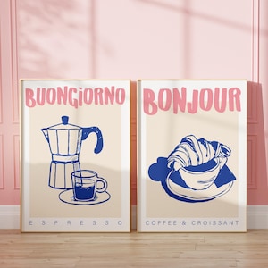 Puede incluir: Dos impresiones enmarcadas con una estética vintage. La impresión de la izquierda presenta una ilustración azul y blanca de una cafetera y una taza de café con el texto "Buongiorno Espresso". La impresión de la derecha presenta una ilustración azul y blanca de un croissant y una taza de café con el texto "Bonjour Coffee & Croissant".