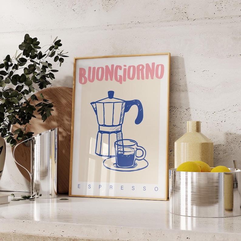Pode incluir: Uma impress&atilde;o emoldurada com uma ilustra&ccedil;&atilde;o azul e branca de uma cafeteira e uma x&iacute;cara de caf&eacute;. O texto "BUONGIORNO ESPRESSO" est&aacute; impresso em rosa e azul.