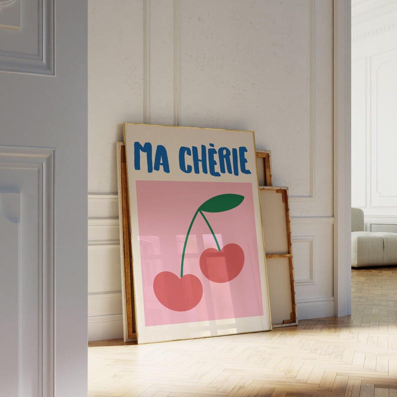 May include: A framed print with a pink background and a green cherry with two red cherries on a stem. The text "MA CH&Eacute;RIE" is in blue letters at the top of the print.