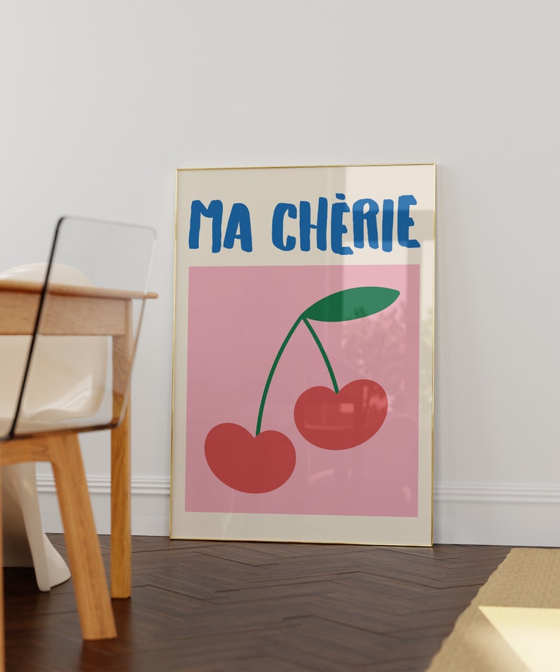 May include: A framed print with a pink background and the text "MA CH&Eacute;RIE" in blue. A green stem with two red cherries is in the center of the print.