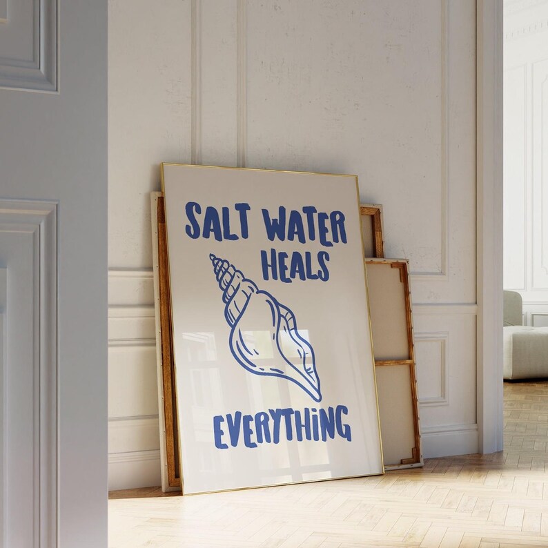 May include: A framed print with a white background and blue text that reads "Salt Water Heals Everything". A blue seashell illustration is centered on the print.