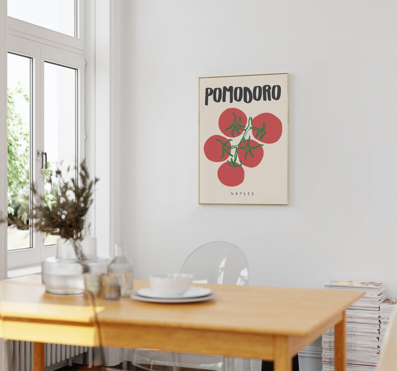 May include: A framed poster with a minimalist design featuring a red tomato vine with the text "POMODORO NAPLES" in black.