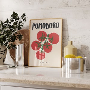 May include: A framed print with the word "POMODORO" in black text and the word "NAPLES" in smaller black text. The print features a stylized illustration of red tomatoes on a vine with green leaves.