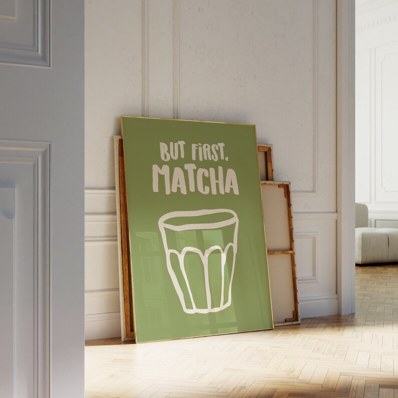 May include: A green poster with a gold frame featuring a white illustration of a cup of matcha and the text "But first, matcha."