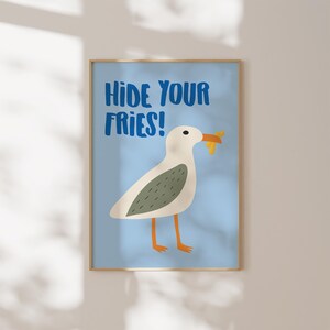 May include: A blue and white printable art print with a cartoon seagull holding a french fry in its beak. The text "Hide Your Fries!" is written in blue letters.