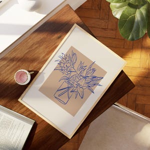 May include: A framed print of a line drawing of a bouquet of blue flowers in a vase on a beige background.