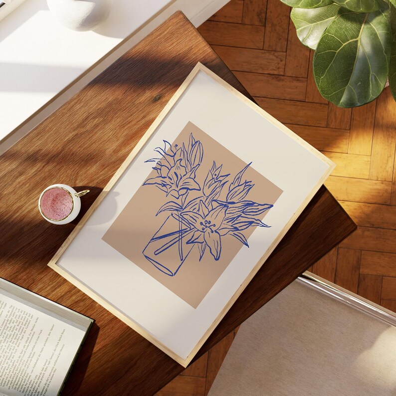 May include: A framed print of a line drawing of a bouquet of blue flowers in a vase on a beige background.