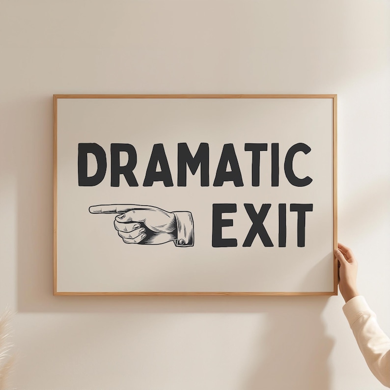 May include: A white framed sign with black text that reads "Dramatic Exit" with a black and white illustration of a hand pointing to the right.