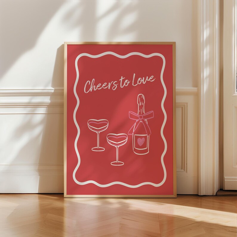 K&ouml;nnte beinhalten: Ein roter Poster mit einem wei&szlig;en Rand und einer wei&szlig;en, wellenf&ouml;rmigen Linie am Rand. Der Poster sagt "Cheers to Love" in wei&szlig;em Text. Es gibt eine rosa Champagnerflasche mit einem rosa Herzen darauf und zwei rosa Champagnergl&auml;ser mit rosa Herzen auf den Schalen.
