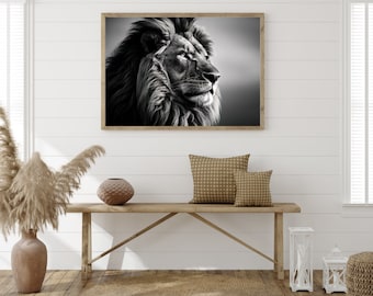 Op de afbeelding: Zwart-witfoto van een leeuwenkop met een majestueuze manen. De leeuw kijkt naar rechts van het frame. De foto is ingelijst in een zwart frame en hangt aan een witte muur.