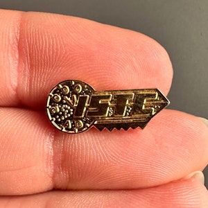 Puede incluir: Pin de forma de llave de color dorado con la palabra "LITE" en letras en relieve en la parte de la llave y un diseño circular en la parte del ojo de la llave.