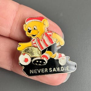 Gelber Bär rot-weißes Shirt Fußballer Never Say Die Kicker Fußball Emaille Anstecknadel Abzeichen Brosche