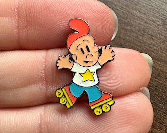 Könnte beinhalten: Eine Emaille-Anstecknadel mit einem Comic-Charakter auf Rollschuhen. Der Charakter trägt einen roten Hut, ein weißes Hemd mit einem gelben Stern, eine blaue Hose und rote Rollschuhe mit gelben Rädern.