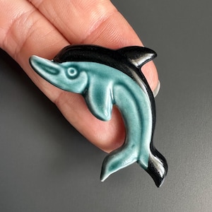 Broche vintage de golfinho em cerâmica Poole Pottery, esmalte azul e preto, década de 1980.
