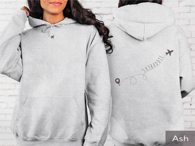 May include: A gray hoodie with a small airplane graphic on the front and a larger airplane graphic with the text "SKYBADDIE" on the back. The hoodie is made of a soft, comfortable material and has a drawstring hood.