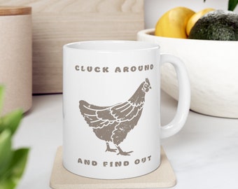 May include: White ceramic mug with a brown chicken illustration and the text "Cluck Around and Find Out".