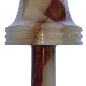 May include: A decorative onyx candle holder with a flared top and a round base. The candle holder features a mix of white, brown, and red hues, creating a marbled effect. The design includes a cylindrical stem and a tiered accent.
