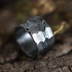 Peut inclure: Gros plan sur une bague en m&eacute;tal fonc&eacute; textur&eacute; avec un motif unique. La bague a un design &agrave; facettes et un int&eacute;rieur poli. La bague est un bijou.